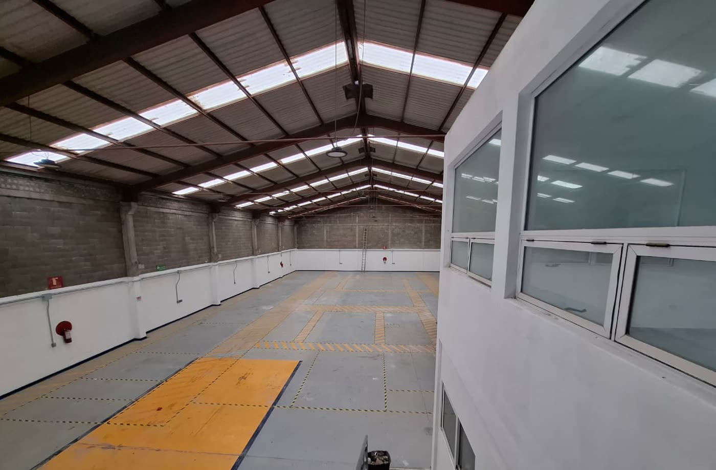 Nave desde el extremo opuesto, con el módulo de oficinas de dos niveles y su escalera.