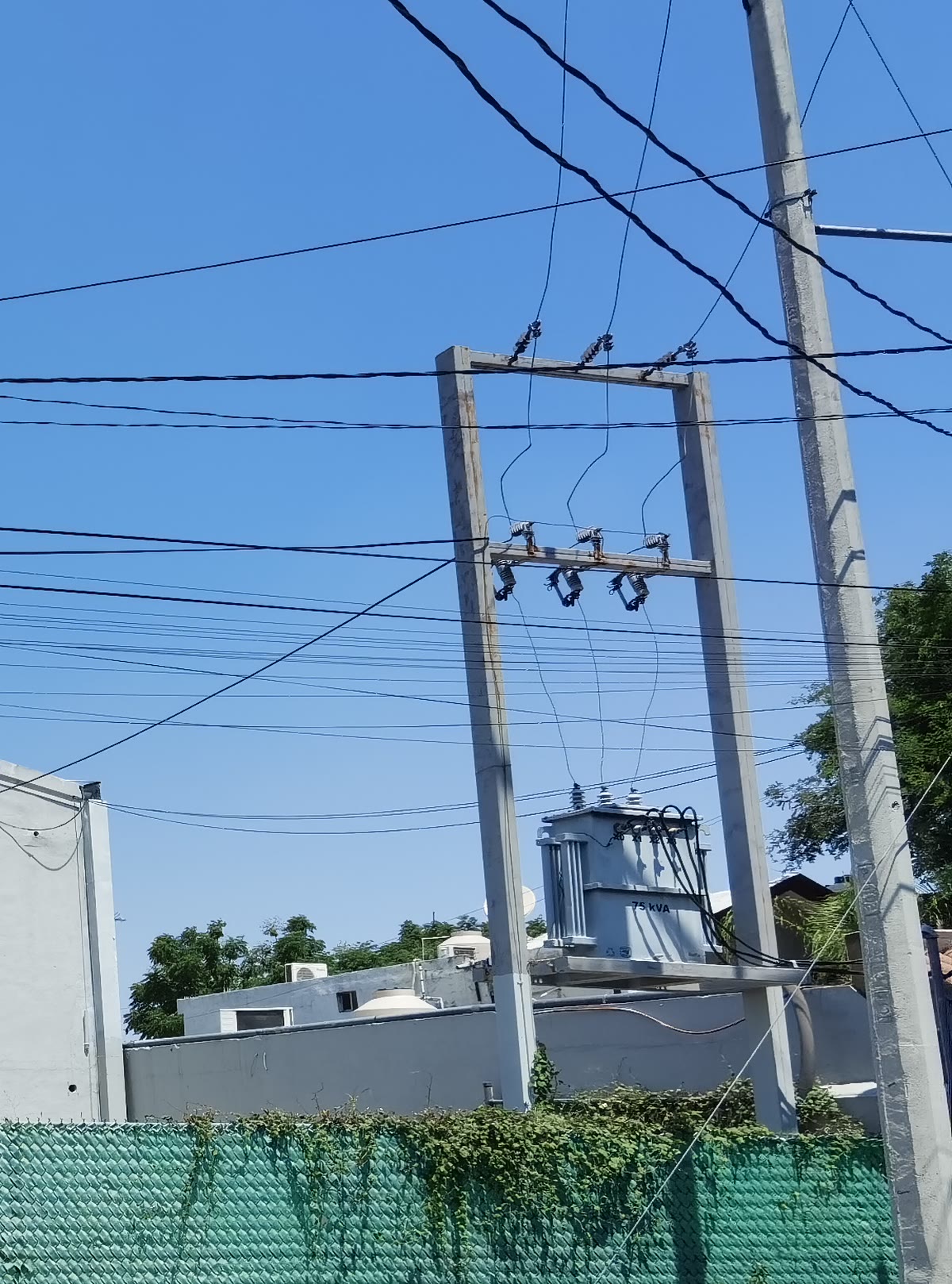 Subestación del inmueble: estructura de dos postes con crucetas, tres cuchillas fusible y el transformador de 75 kVA.
