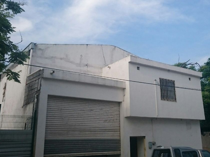 La fachada en abril de 2015: cortina metálica, la oficina de planta alta con ventana enrejada y, detrás, el remate de la nave; a la izquierda, el muro oriente.