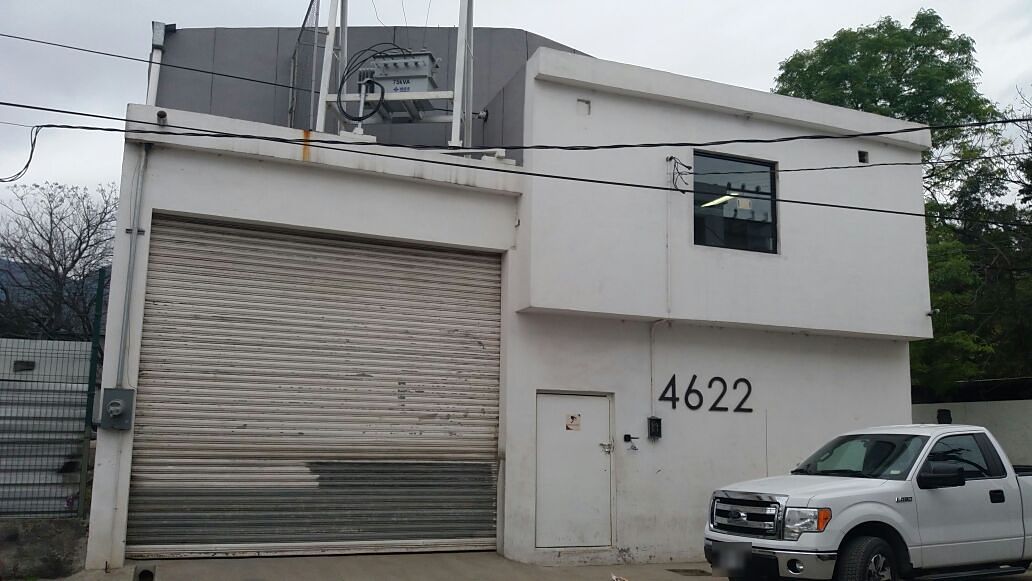 La bodega desde la calle Encino en enero de 2018: fachada blanca con cortina metálica, puerta peatonal, el número 4622 y la oficina de planta alta; sobre la azotea del frente, el transformador de la subestación.