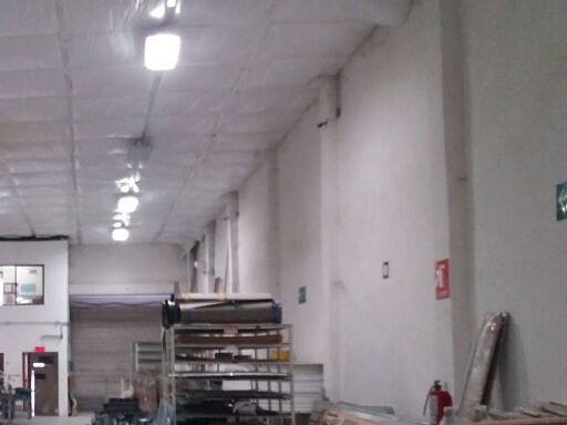 Interior de la nave hacia el frente: la cortina por dentro, el muro oriente con sus columnas y el plafón blanco.