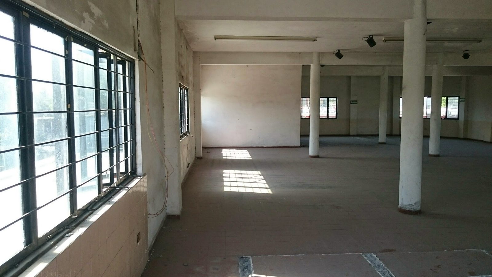 Planta libre de un nivel intermedio con ventanas corridas y columnas.